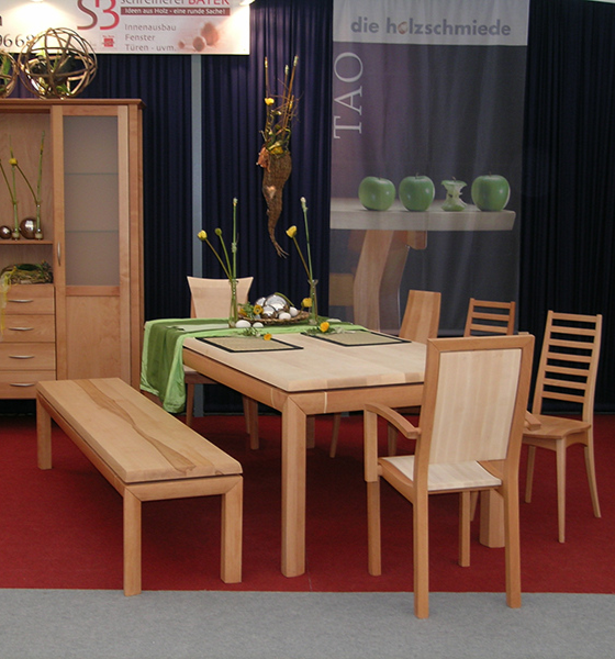 Esszimmer mit massiver Holztafel, passenden Stühlen und Sideboard – warme Holzoberflächen, klares Design und gemütliche Atmosphäre.